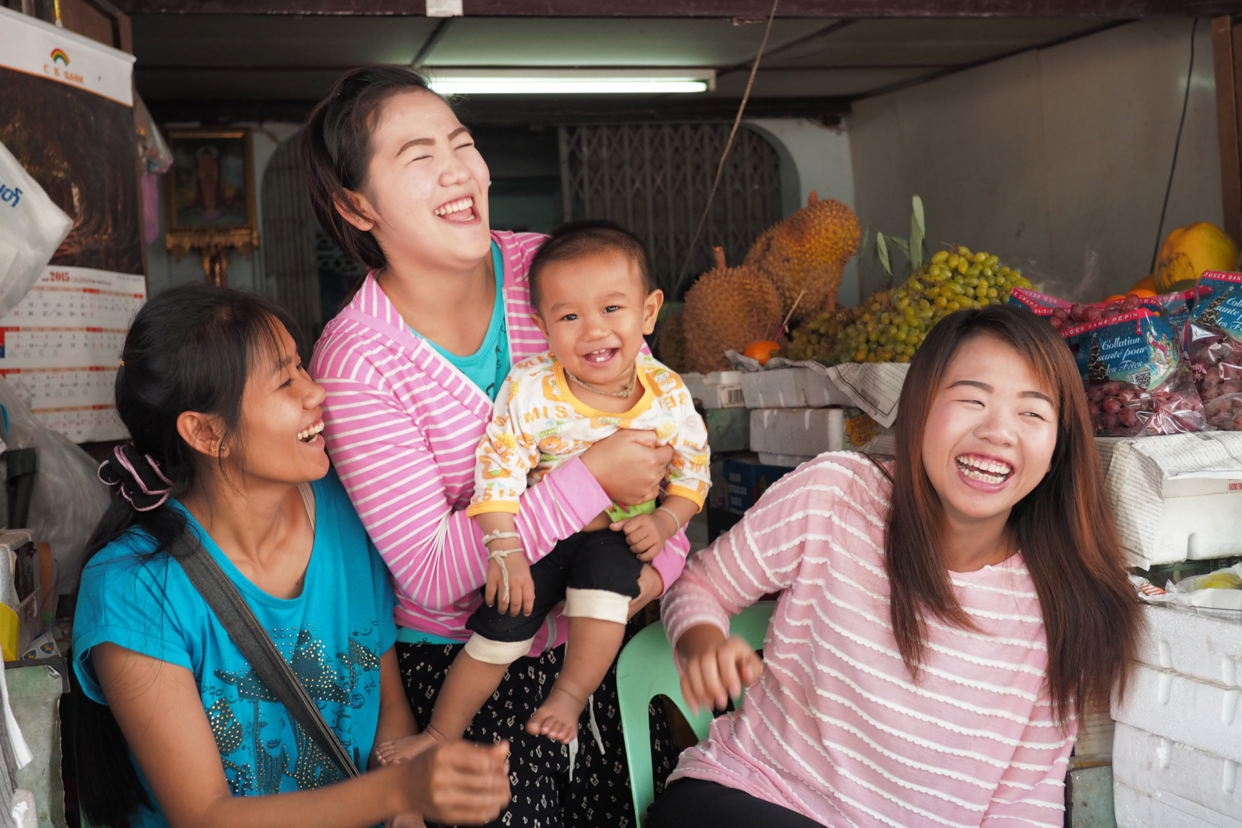 大笑いするミャンマーの果物屋家族